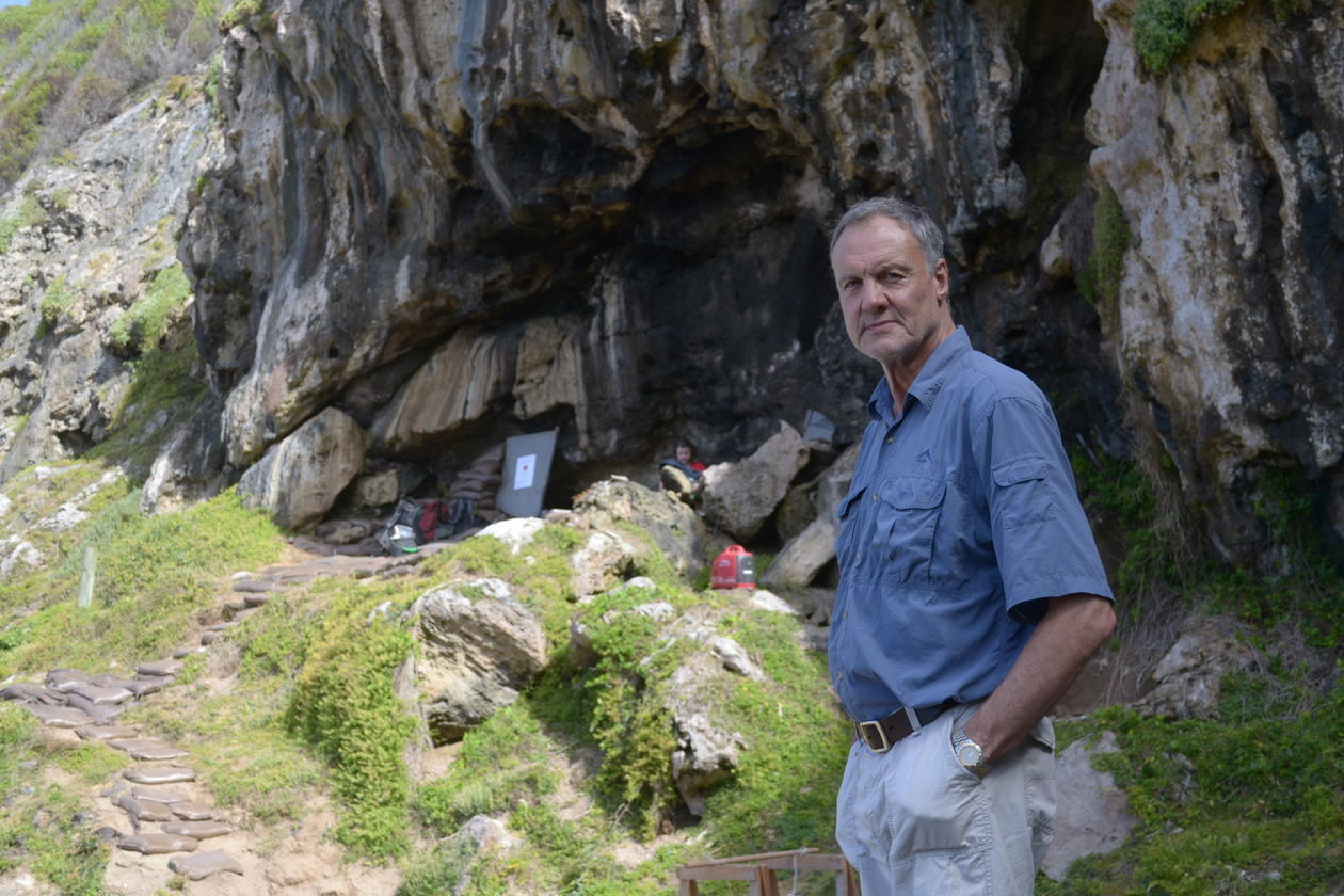 Man in front of a cave