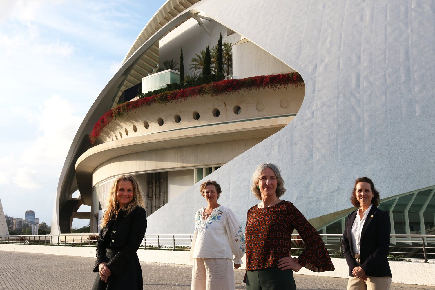 fire kvinner oppstilt foran arkitektur