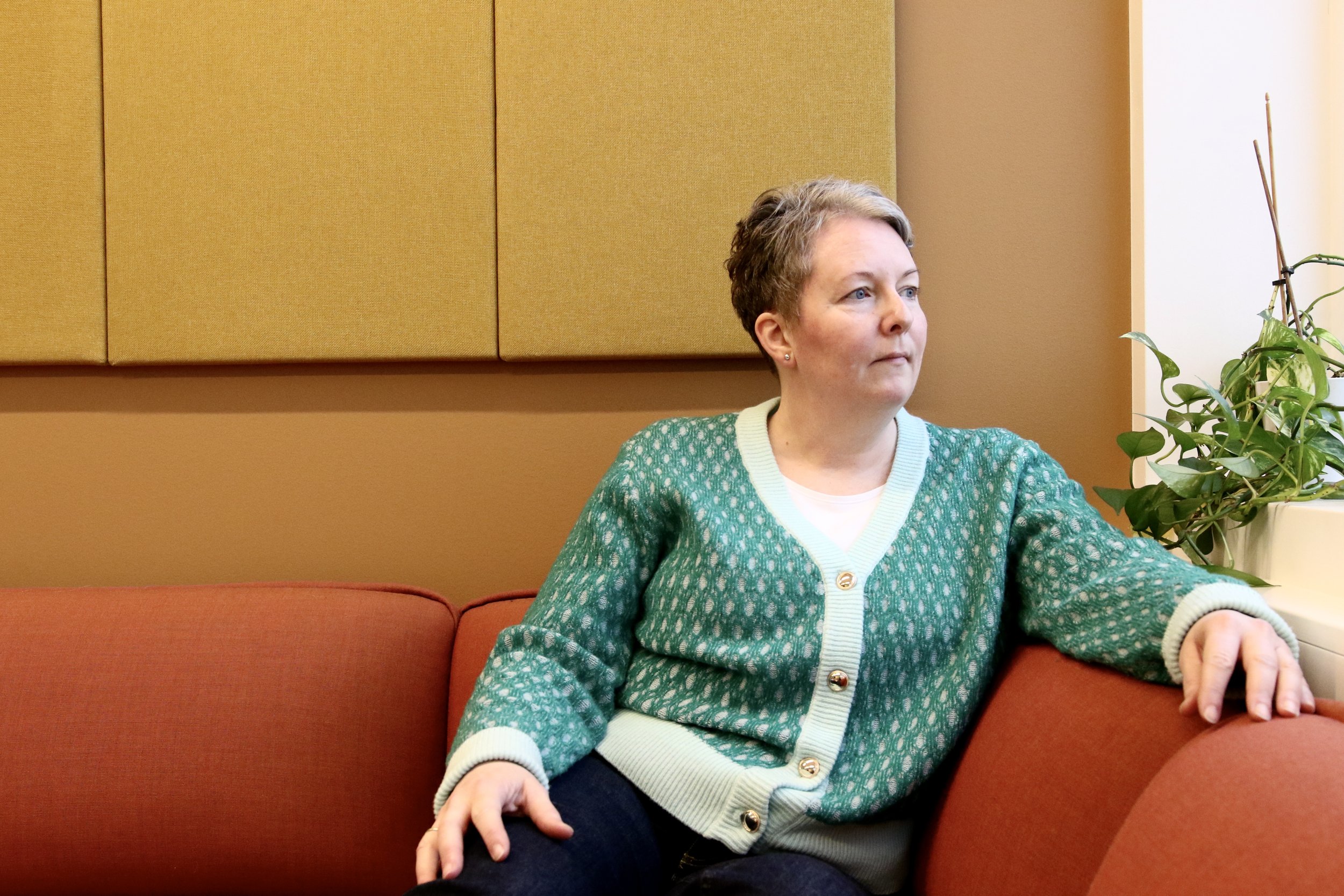 Kjersti Kvamme sitter i en sofa og ser ut vinduet