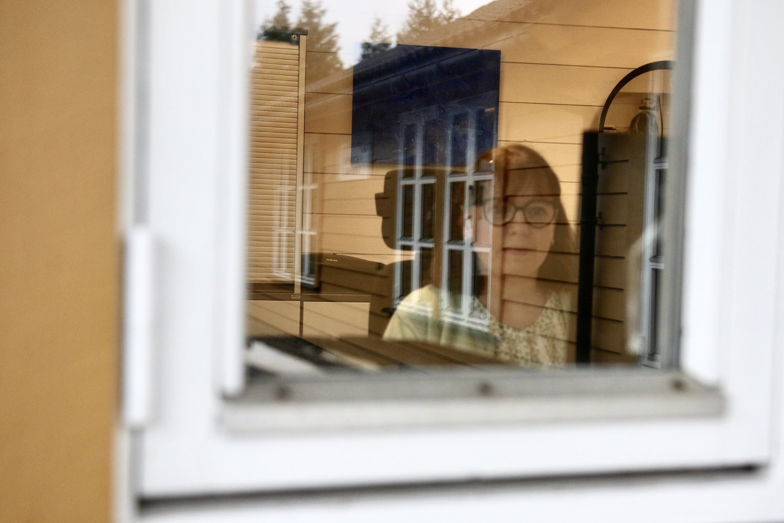 Refleksjon av kvinne i et vindu 