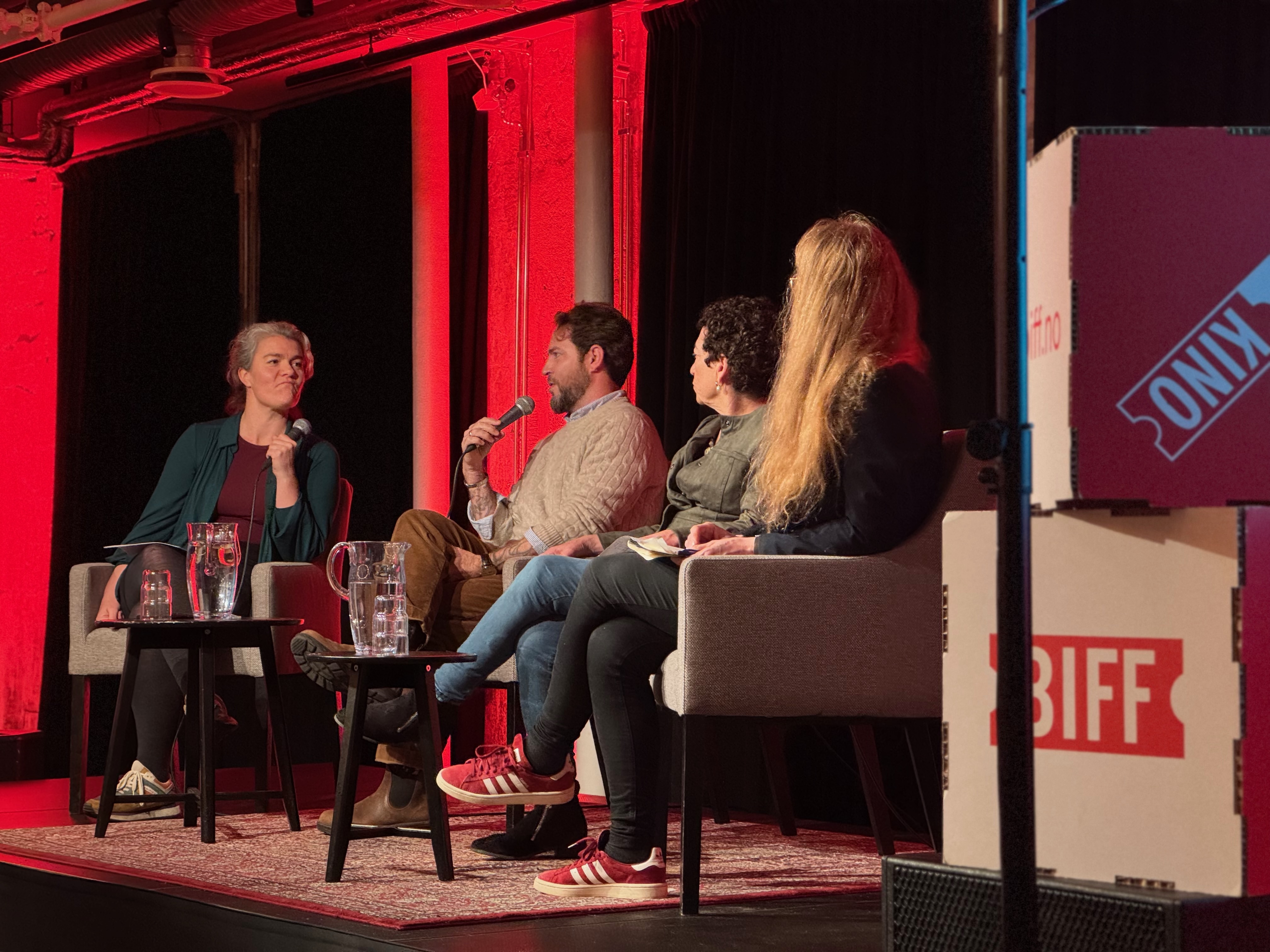 4 people sitting on stage have a panel discussion