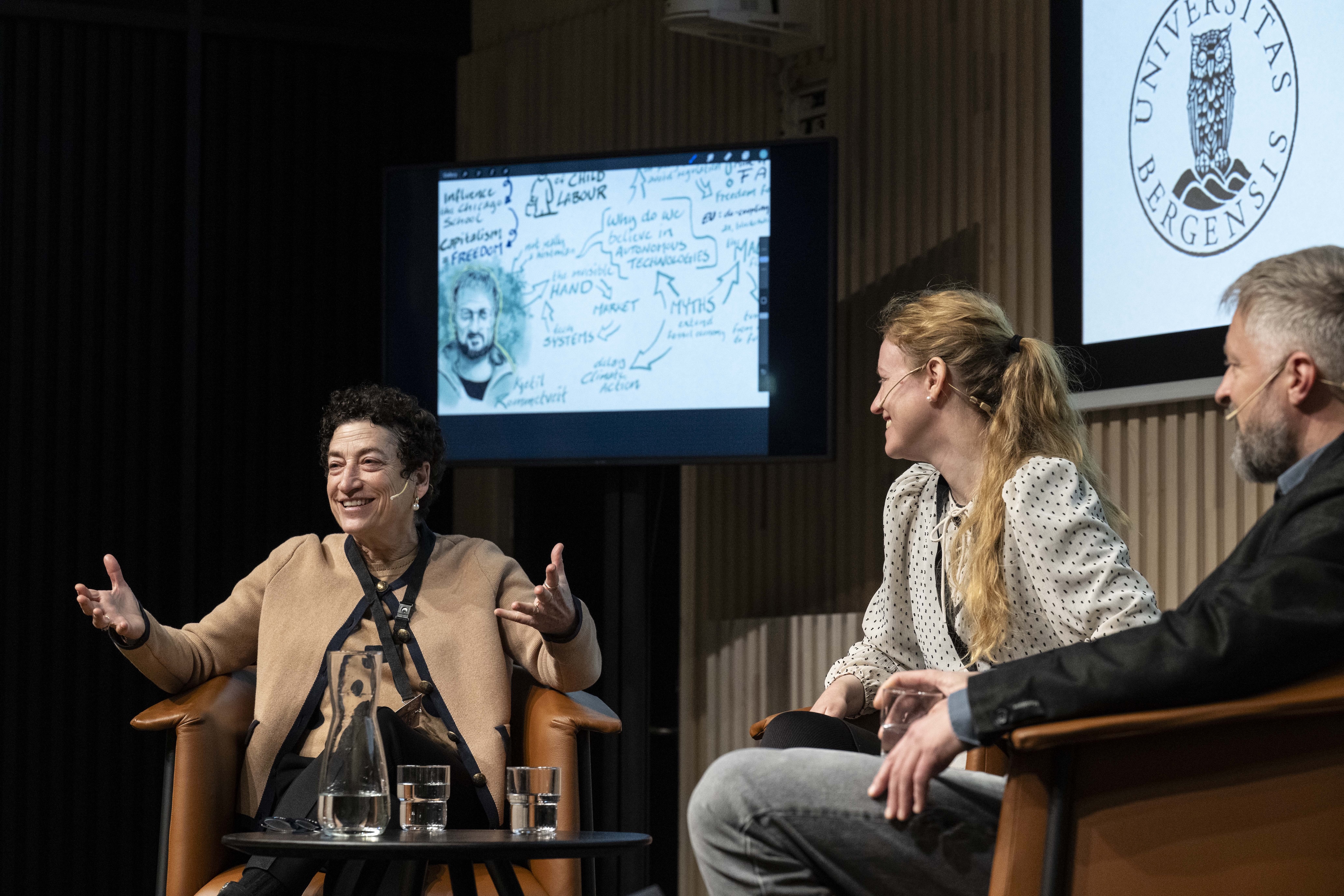 3 people sitting on stage in a discussion