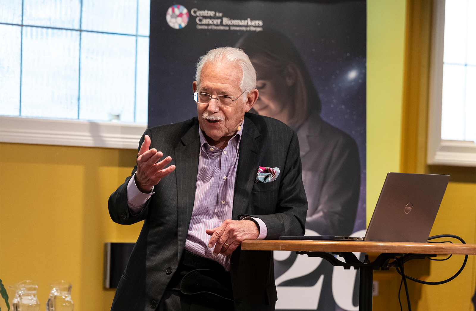 Dr. Haseltine on stage, clearly connecting with the audience, waving his hands while he explains..