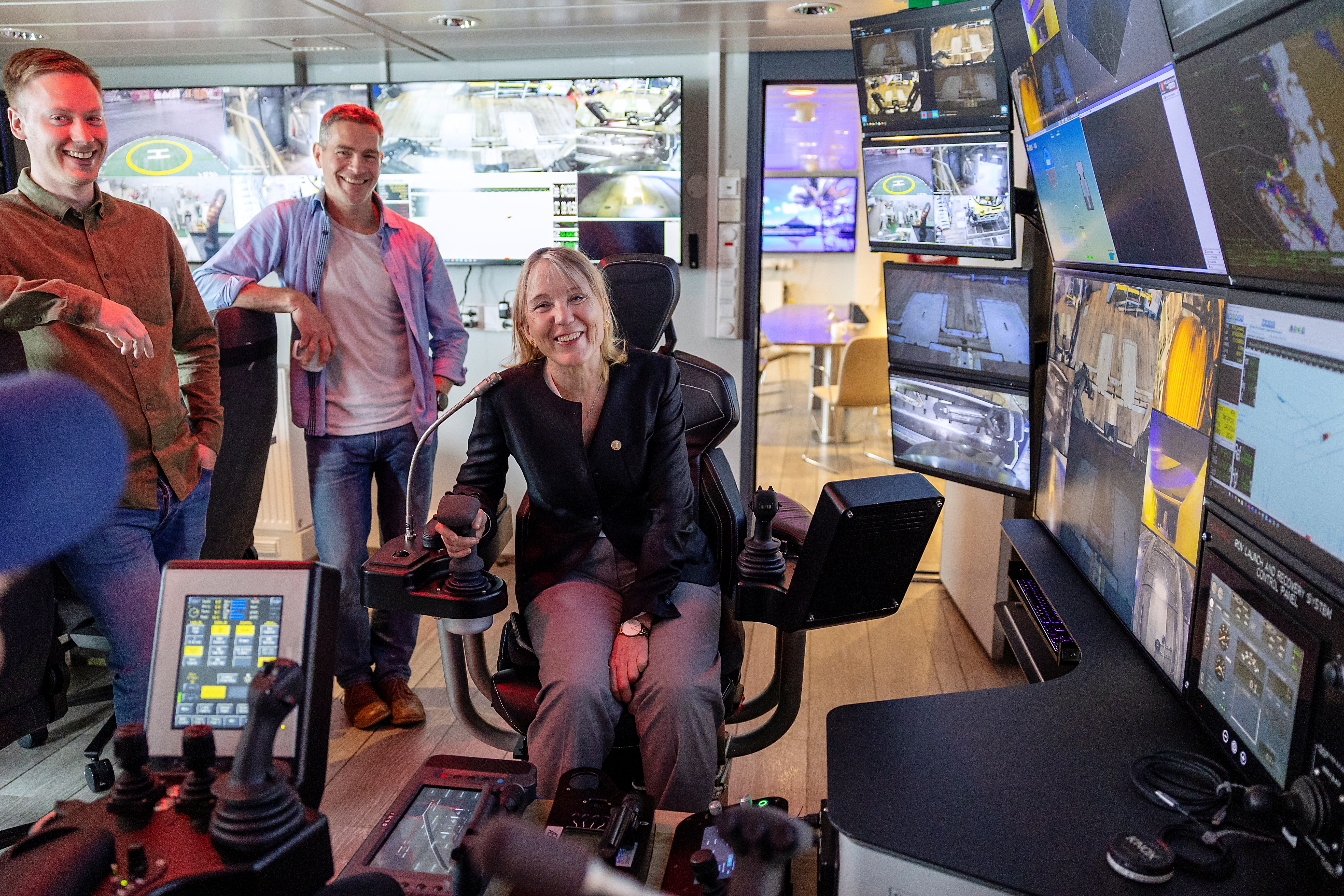 group of 3 people in a control room onboard a ship