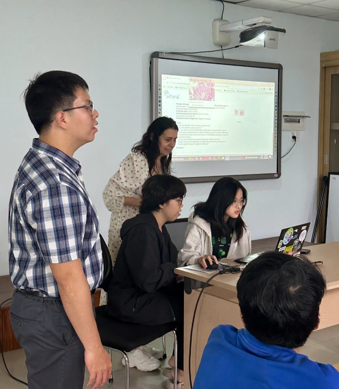 prof. Costea showing a group of students results on a screen.