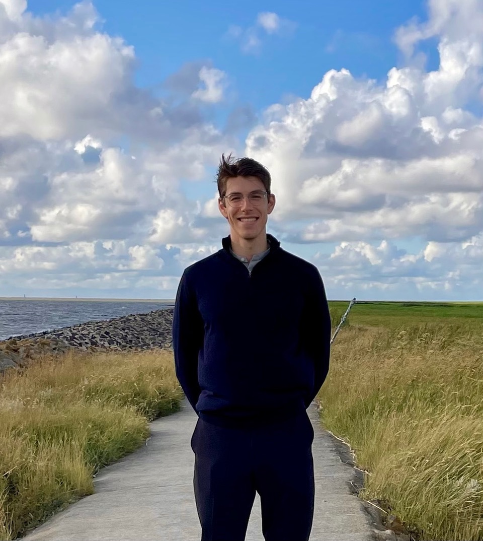 young man walking along a path by the sea