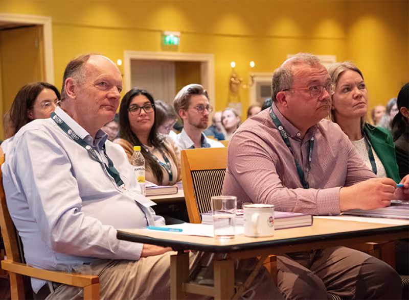 Picture from the audience, a full room, all looking towards the stage.