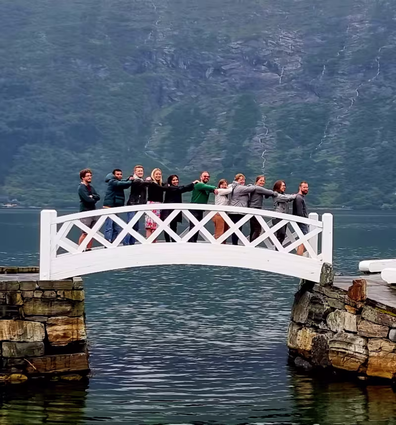 group of researchers posing for the camera on a small bridge