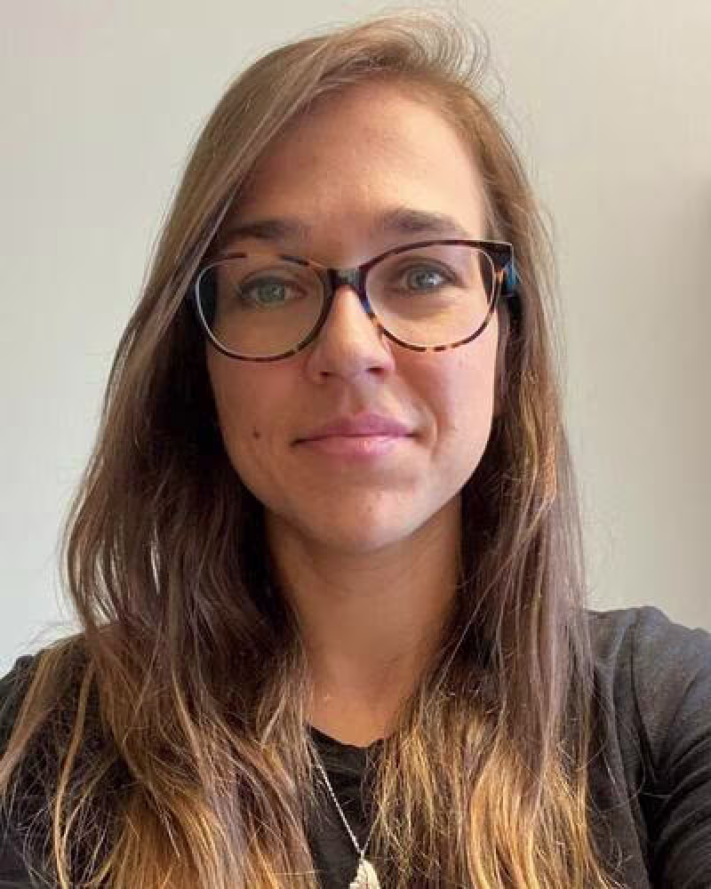 Young woman with long dark hair and glasses