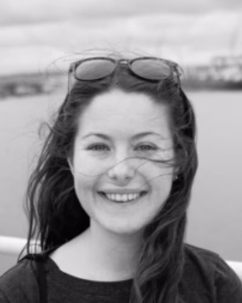 young woman with long dark hair smiling at camera
