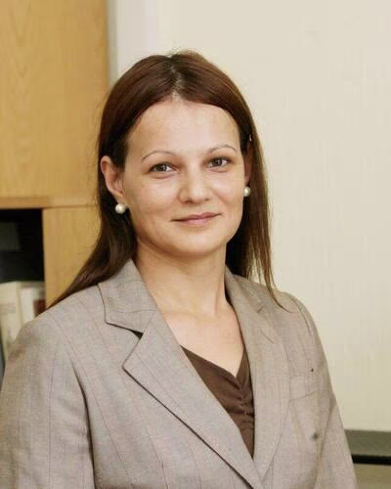 young woman in suit smiles at camera