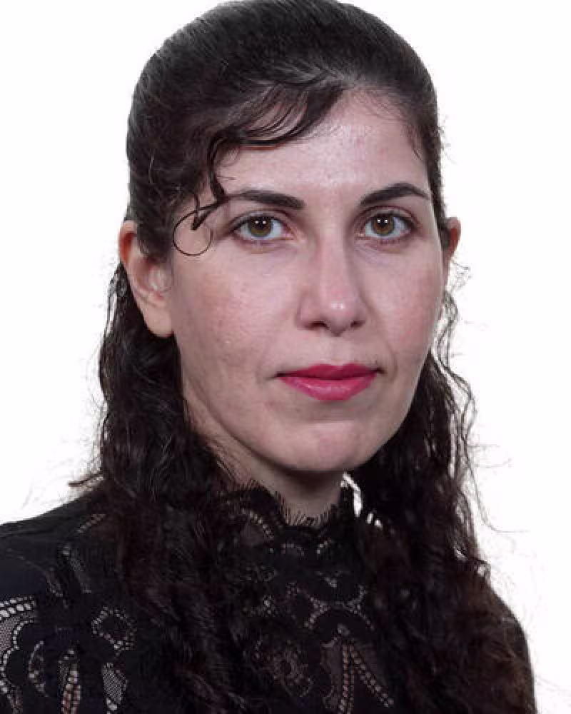 young woman with long dark hair looks at camera