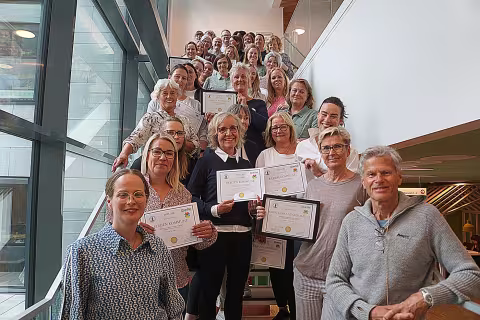 A large group of people standing in a stairs, posing for the camera.