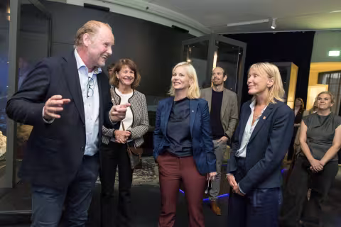 A group of people listen to a man