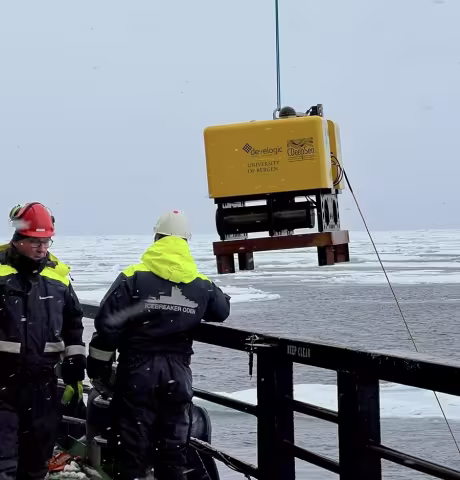 Large yellow box is lowered off a ship into the ocean