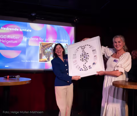 Bettina on stage receiving a work of art.