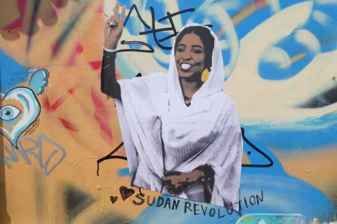 Grafitti på vegg viser kvinne med teksten 'sudan revolution' under