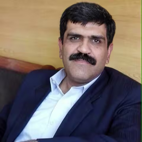 Male person sitting smiling at camera