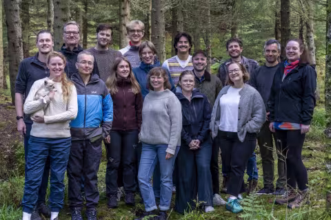 Group of people in a forrest smiling at the camera