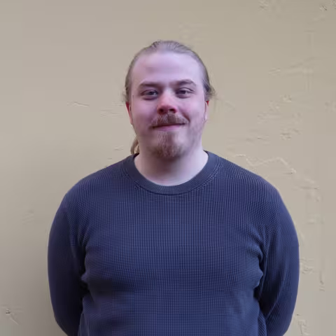 A picture of Magne Oldeide in front of a wall, looking at the camera.
