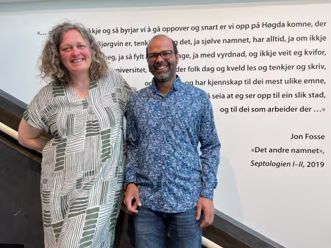Two people smile to the camera