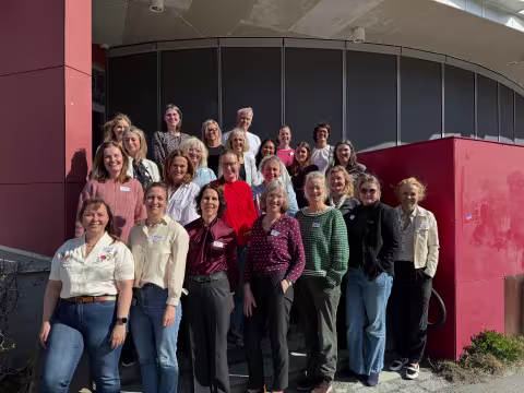 kvinner oppstilt utenfor en rund bygning