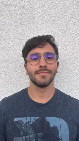 young man with glasses smiling at camera