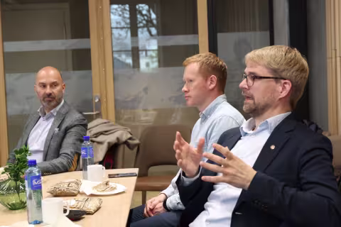 tre menn rundt et bord