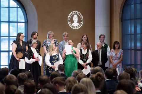 En rekke avgangsstudenter på scenen i UiBs aula.