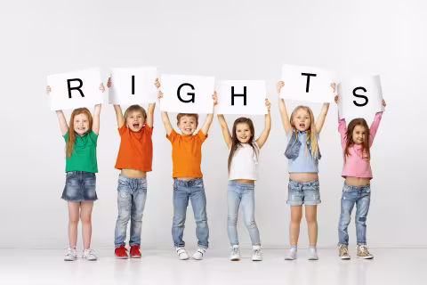 Glade barn som holder et skilt med teksten «rettigheter»