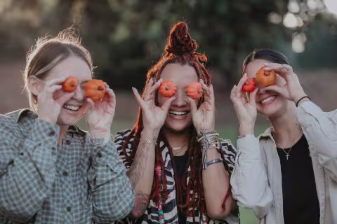 image of women holding pumpkins