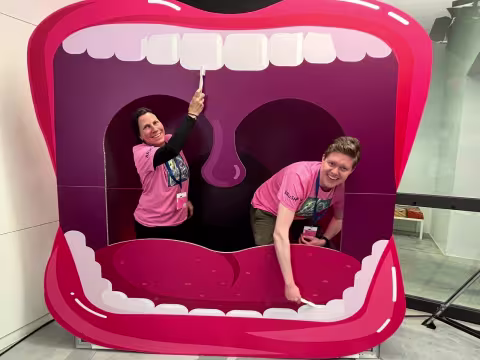 Two researchers inside a big cardboard mouth in the festival booth