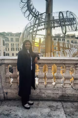 Young woman smiling at camera in front of statue