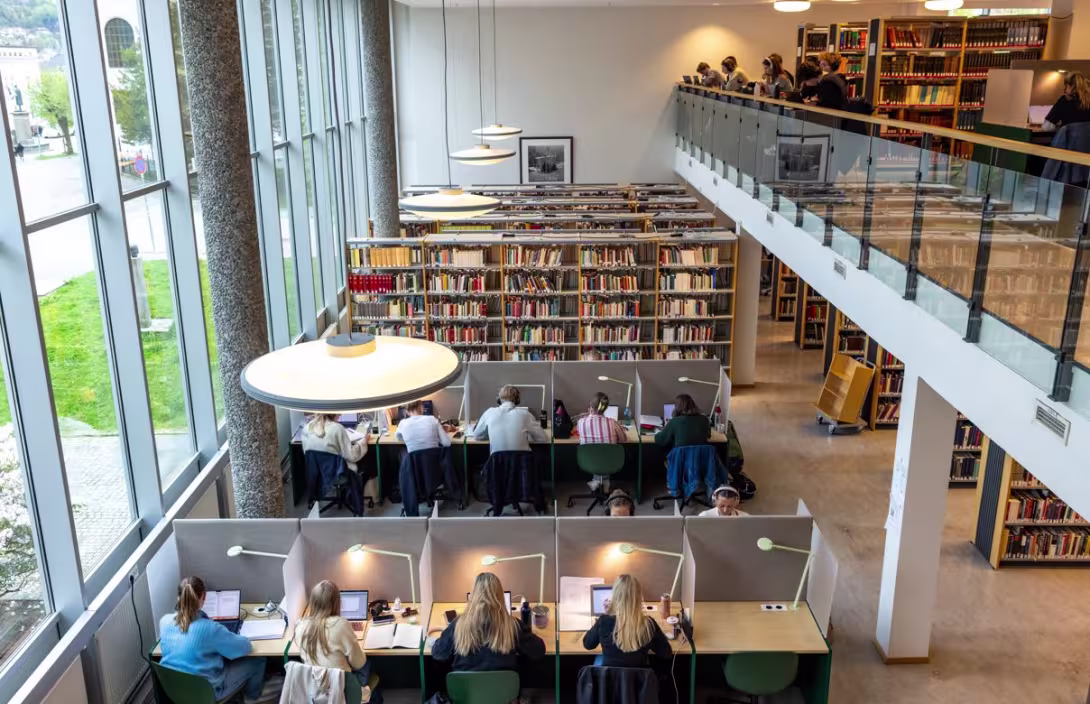 Flere studenter som bruker leseplassene på Universitetsbiblioteket. Bildet tatt ovenfra. 