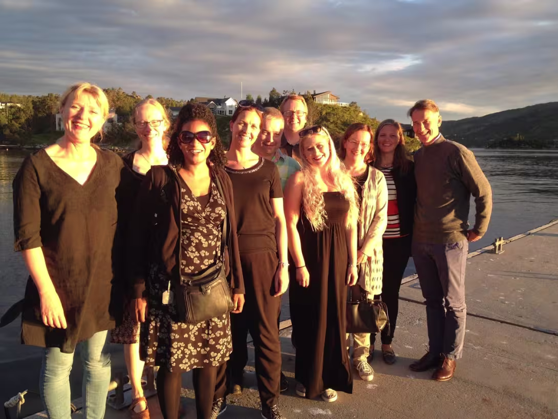 The Tropical Infectious Diseases Group standing on a dock by the water.
