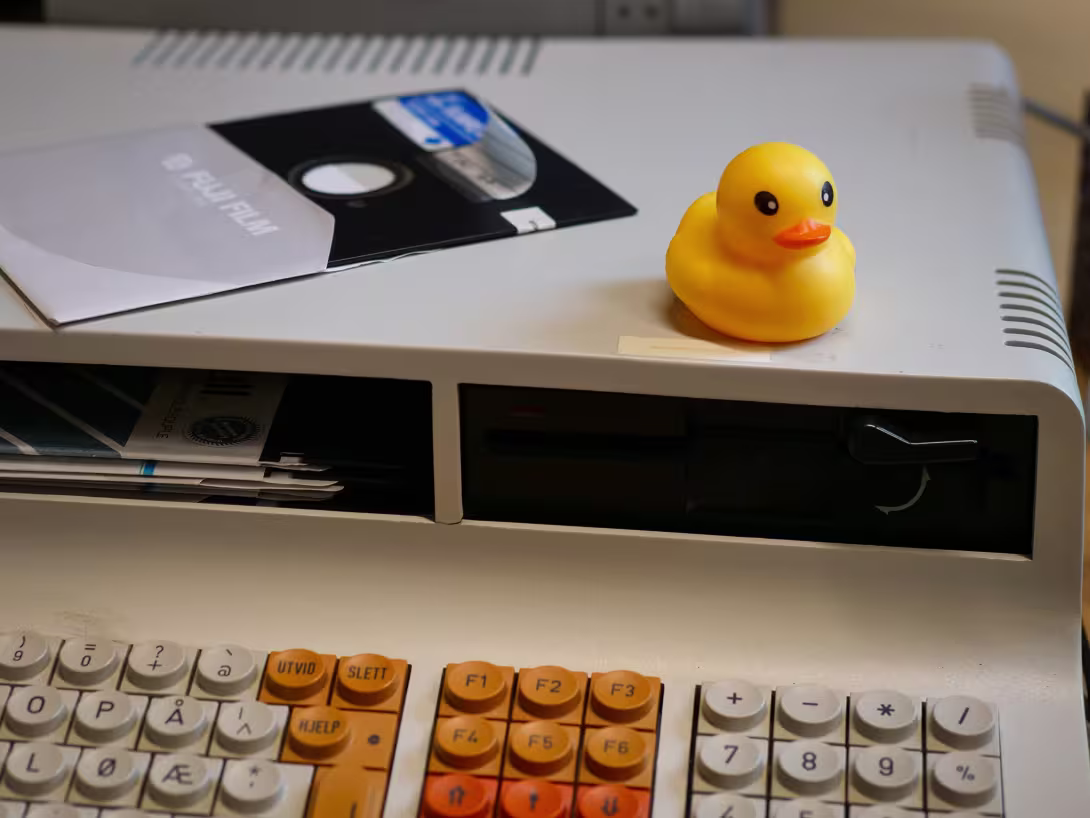 Rubber duck and floppy disk on top of old computer