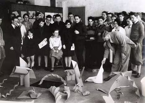 black and white photo of a group of people assesing art work