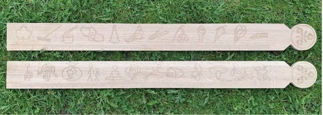 Two primstavs (perpetual calendars) in wood on grass