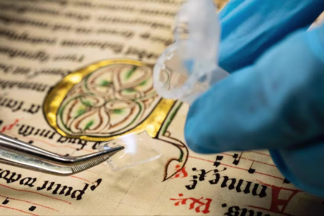 Researcher with gloves studying a medieval fragment