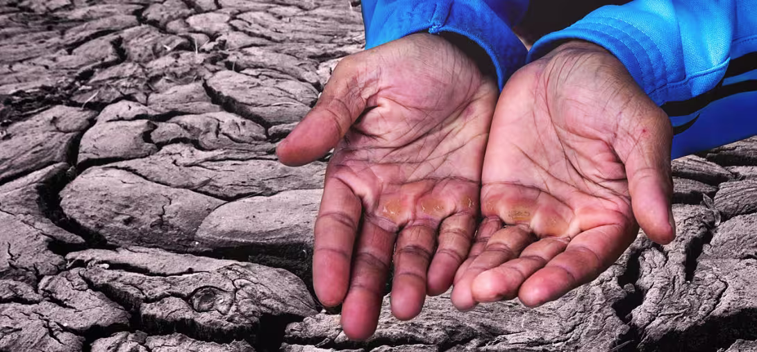 Mann med åpne hender på uttørket land