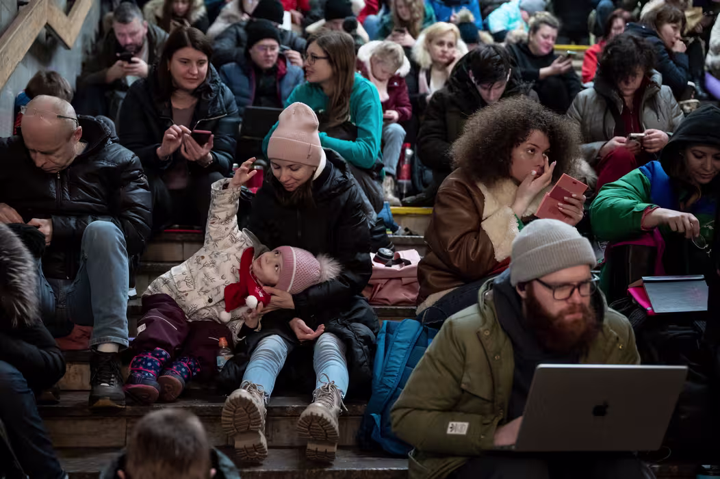 Ukrainere sitter i en trapp på undergrunnsstasjon mens de søker midlertidig ly.