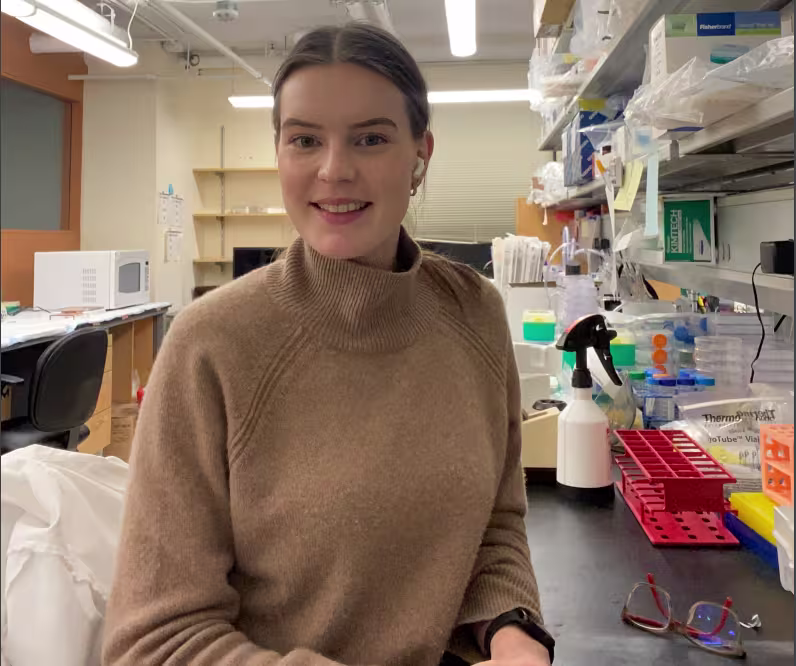 A young woman sitting in a laboratory.