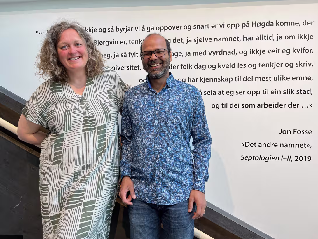 Two people smile to the camera