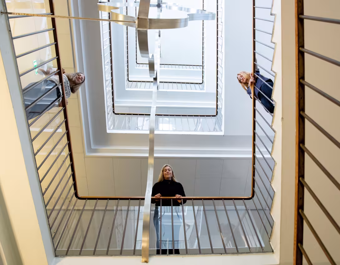 Bilder av tre studenter i trappehuset i Christies gate 12